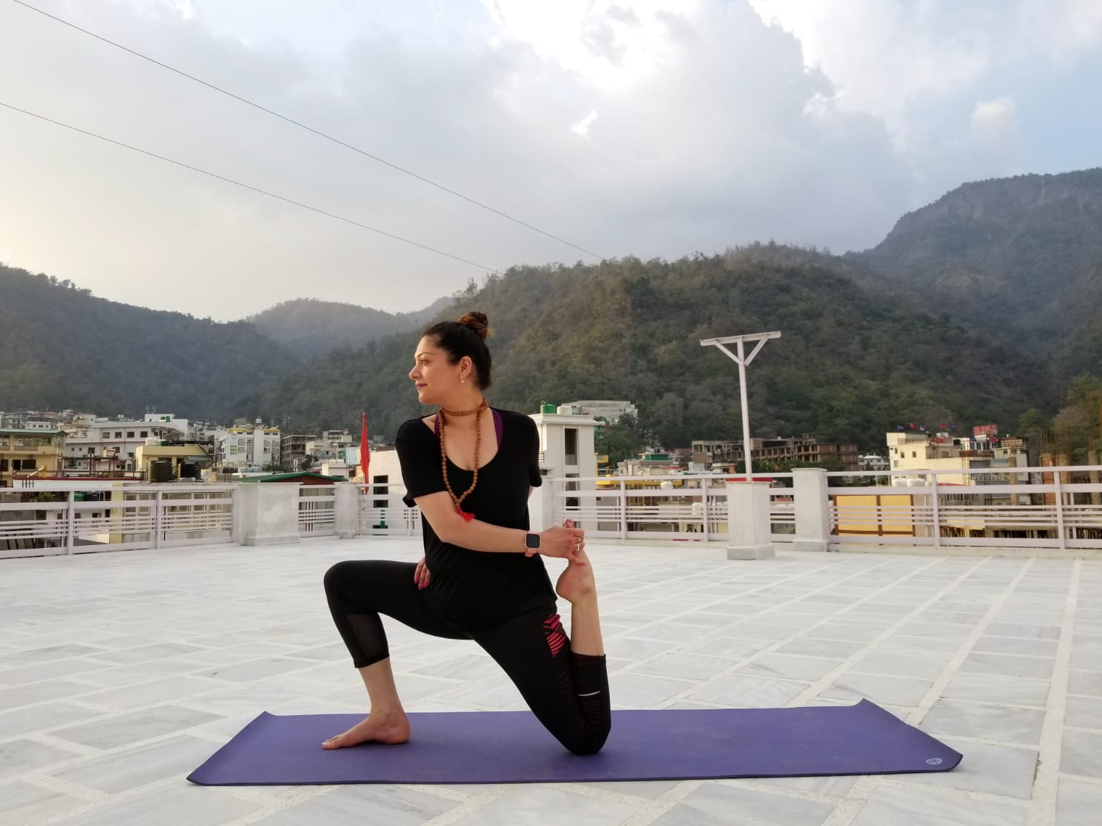 Nidhi in a yoga pose on a rooftop 1.