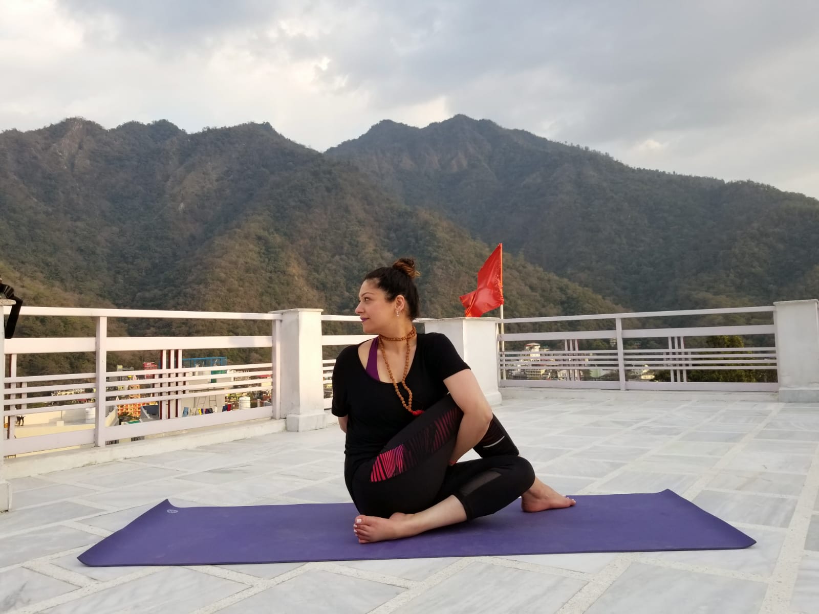Nidhi in a yoga pose on a rooftop 2.