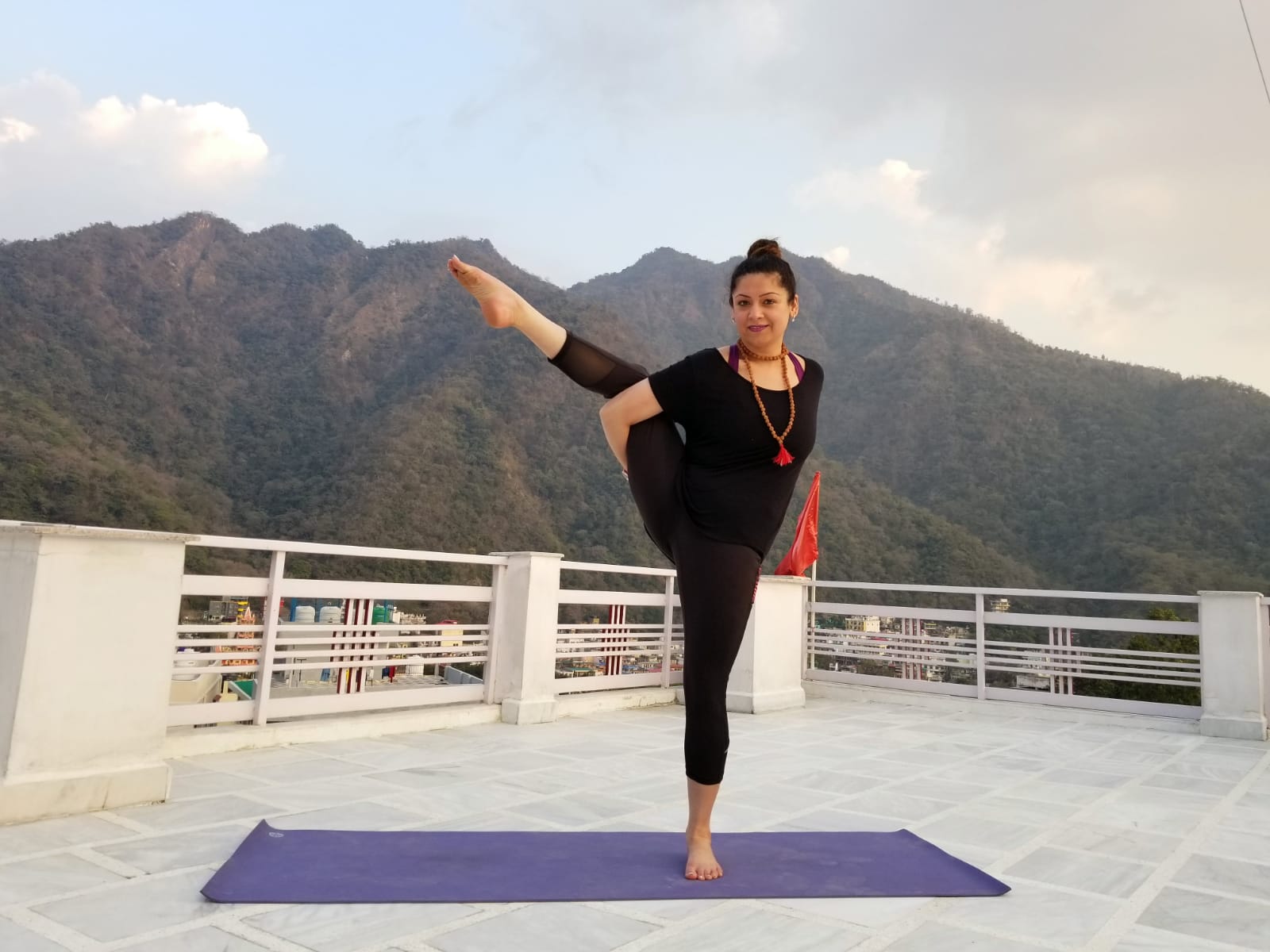 Nidhi in a yoga pose on a rooftop 7.